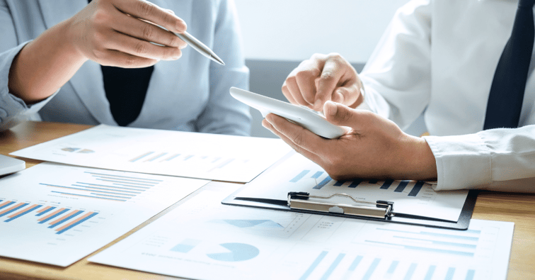 two people reviewing numbers on a calculator (1)-png