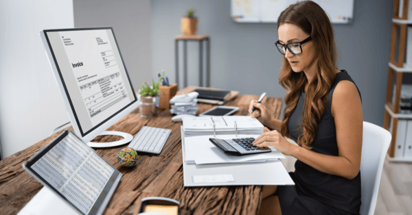 woman sitting down at desk with calculator (1)-png
